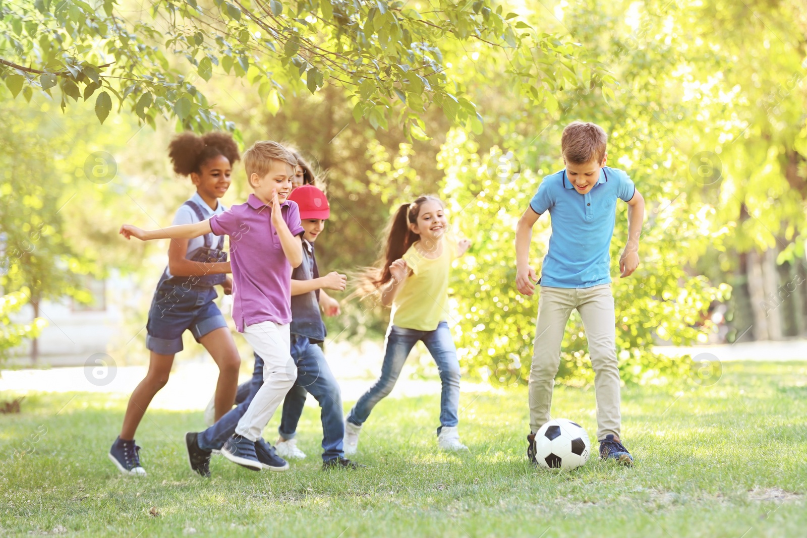 Photo of Cute little children playing with ball outdoors on sunny day