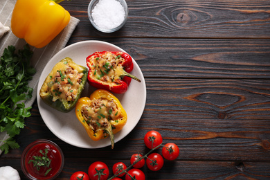 Photo of Flat lay composition with tasty stuffed bell peppers on wooden table, space for text
