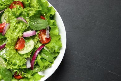 Photo of Delicious salad in bowl on grey table, top view