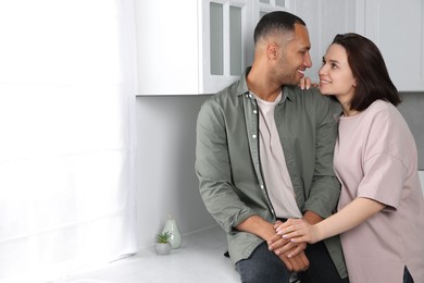 Photo of Dating agency. Happy couple spending time together in kitchen, space for text