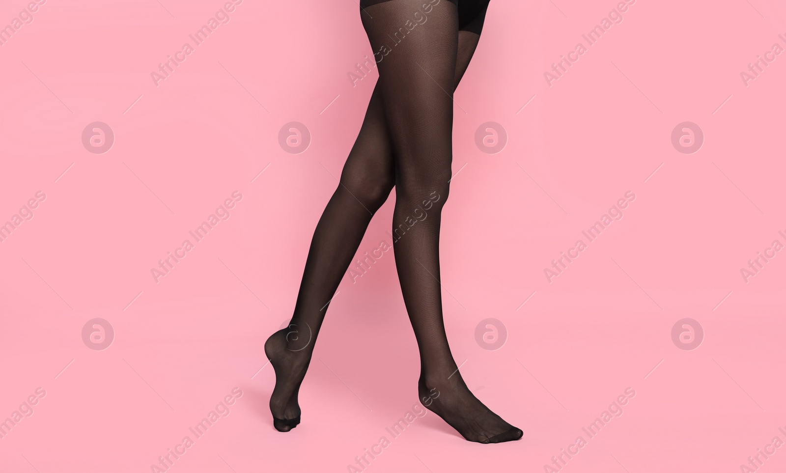 Photo of Woman wearing black tights on pink background, closeup. Space for text