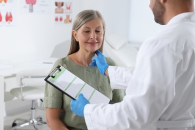 Endocrinologist examining thyroid gland of patient at hospital, closeup