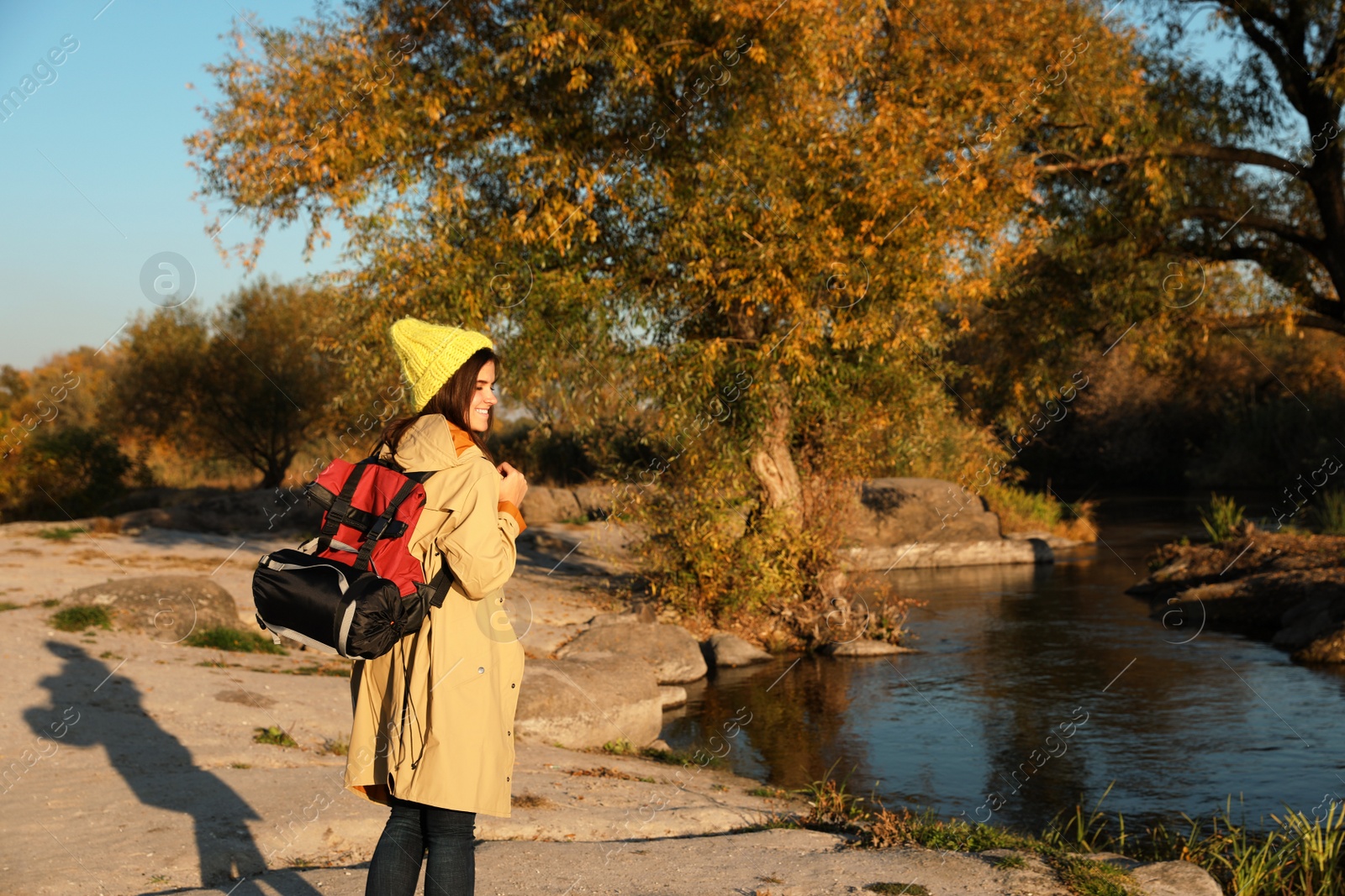 Photo of Female camper with backpack and sleeping bag in wilderness. Space for text