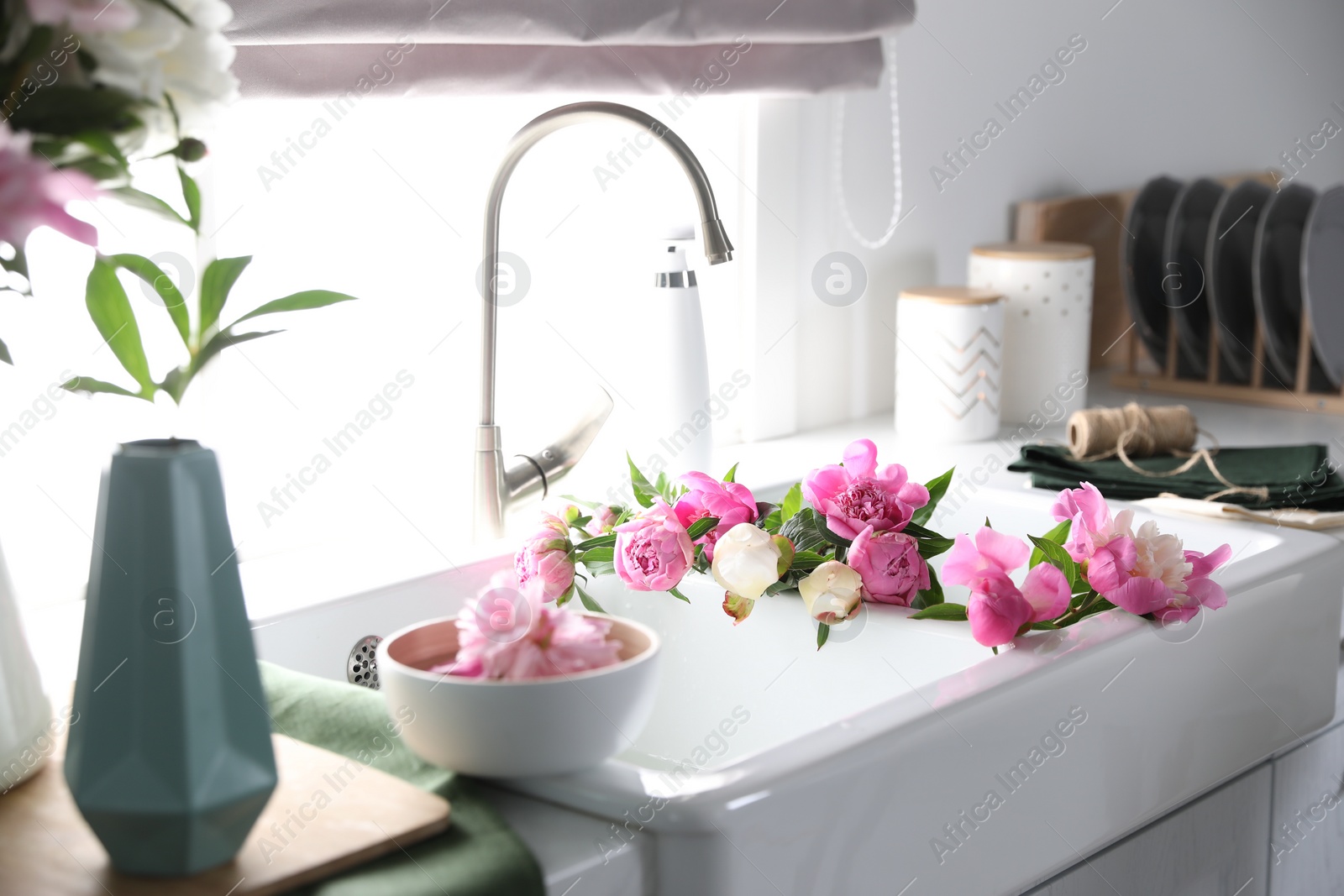 Photo of Bunch of beautiful peonies in kitchen sink