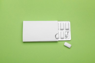 Photo of Blister with chewing gums on pale green background, top view