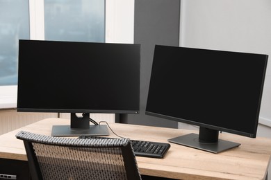 Photo of Modern interior. Workplace with multi-monitor on wooden desk in office, space for text