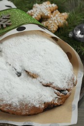 Photo of Wrapped Christmas Stollen with decoration on table, closeup