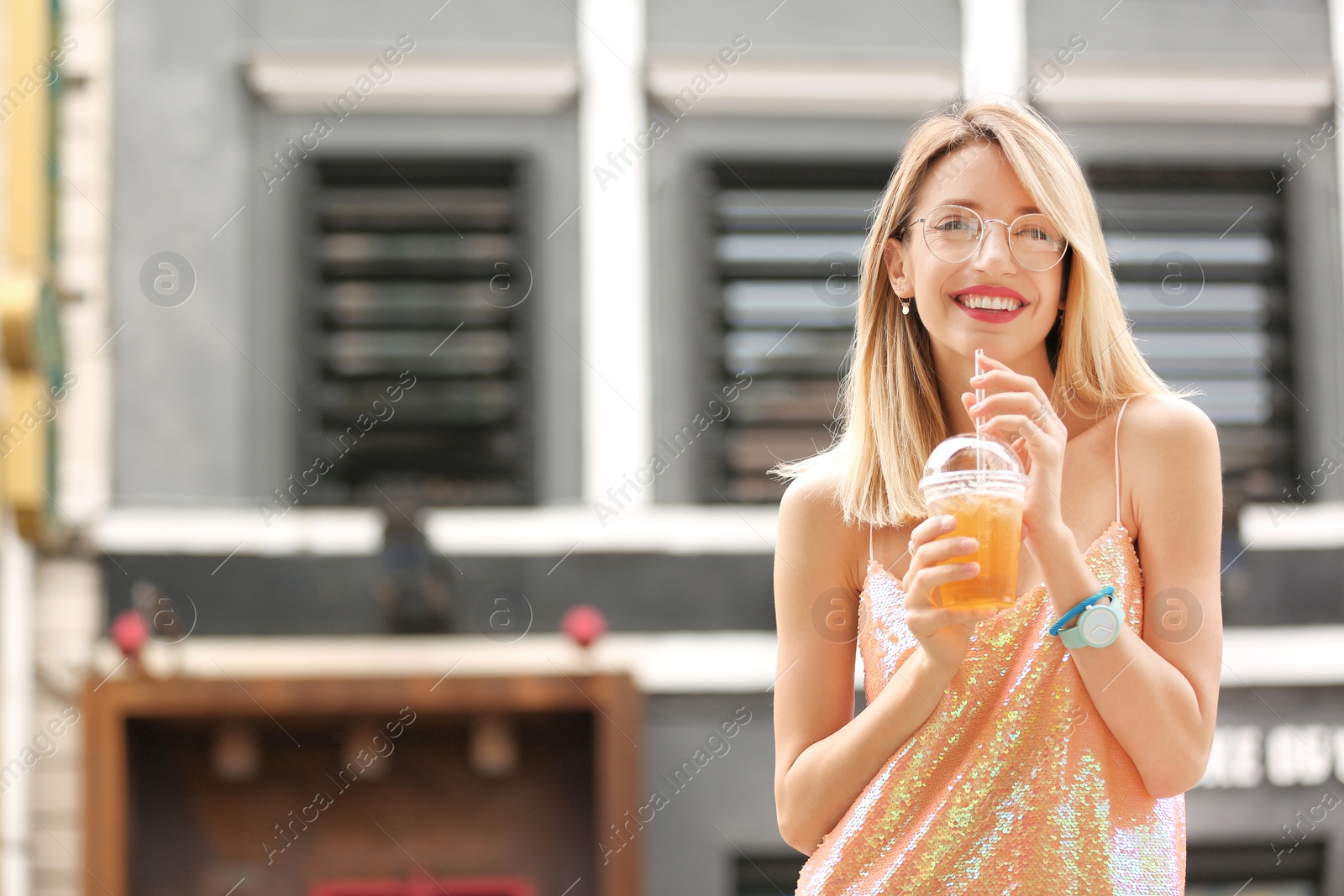 Photo of Young woman with cup of tasty lemonade outdoors