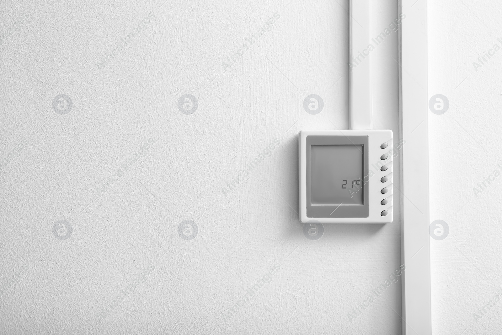 Photo of Modern thermostat and space for text on white wall. Heating system