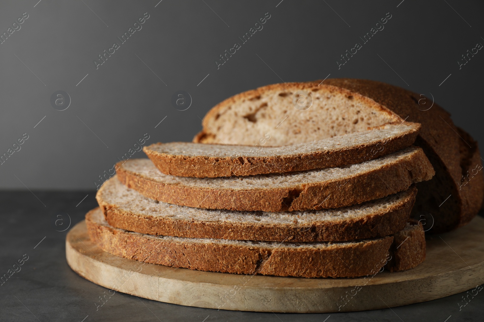 Photo of Freshly baked cut sourdough bread on grey table, closeup