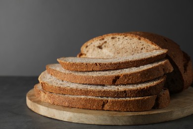 Photo of Freshly baked cut sourdough bread on grey table, closeup