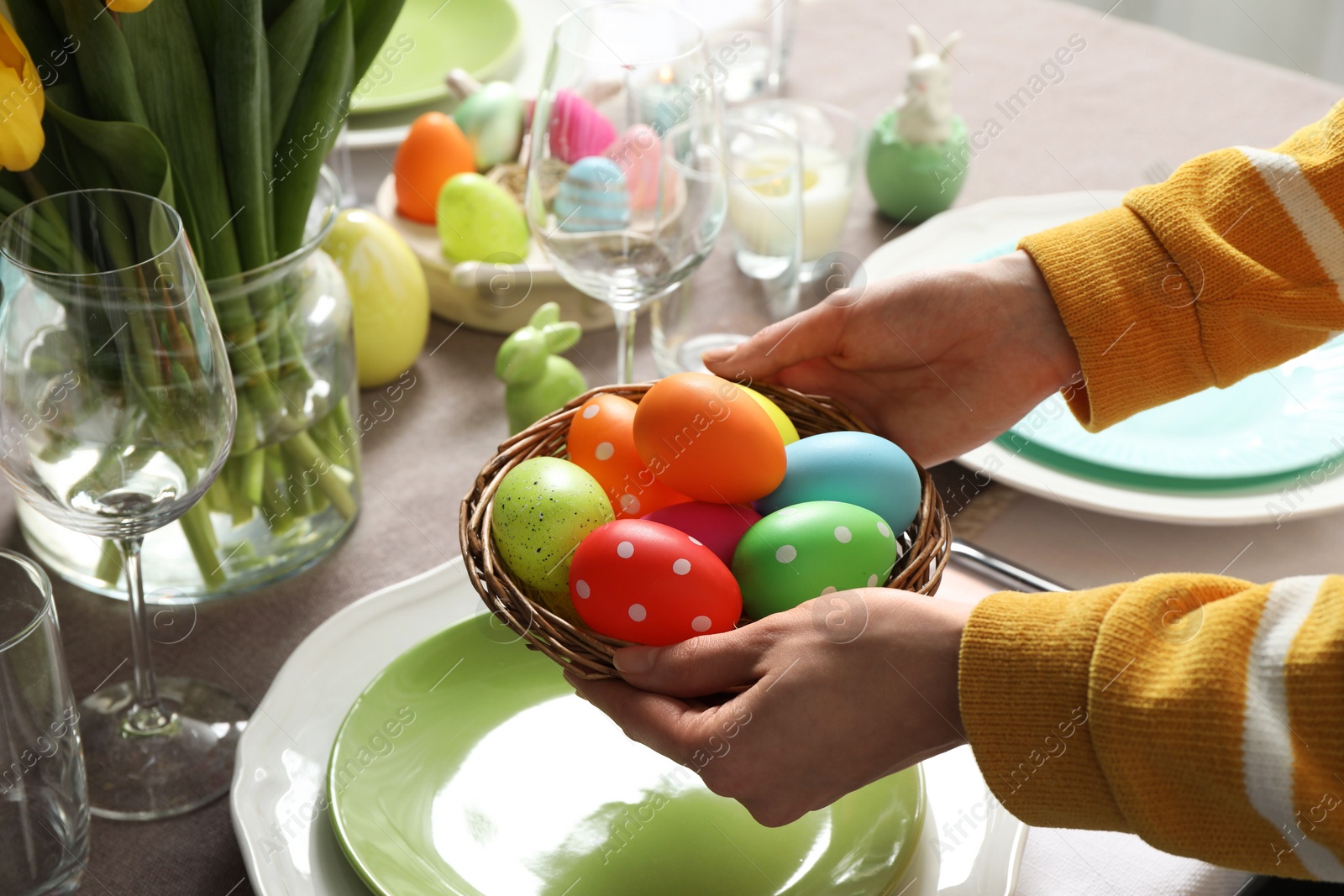 Photo of Woman setting table for festive Easter dinner at home, closeup