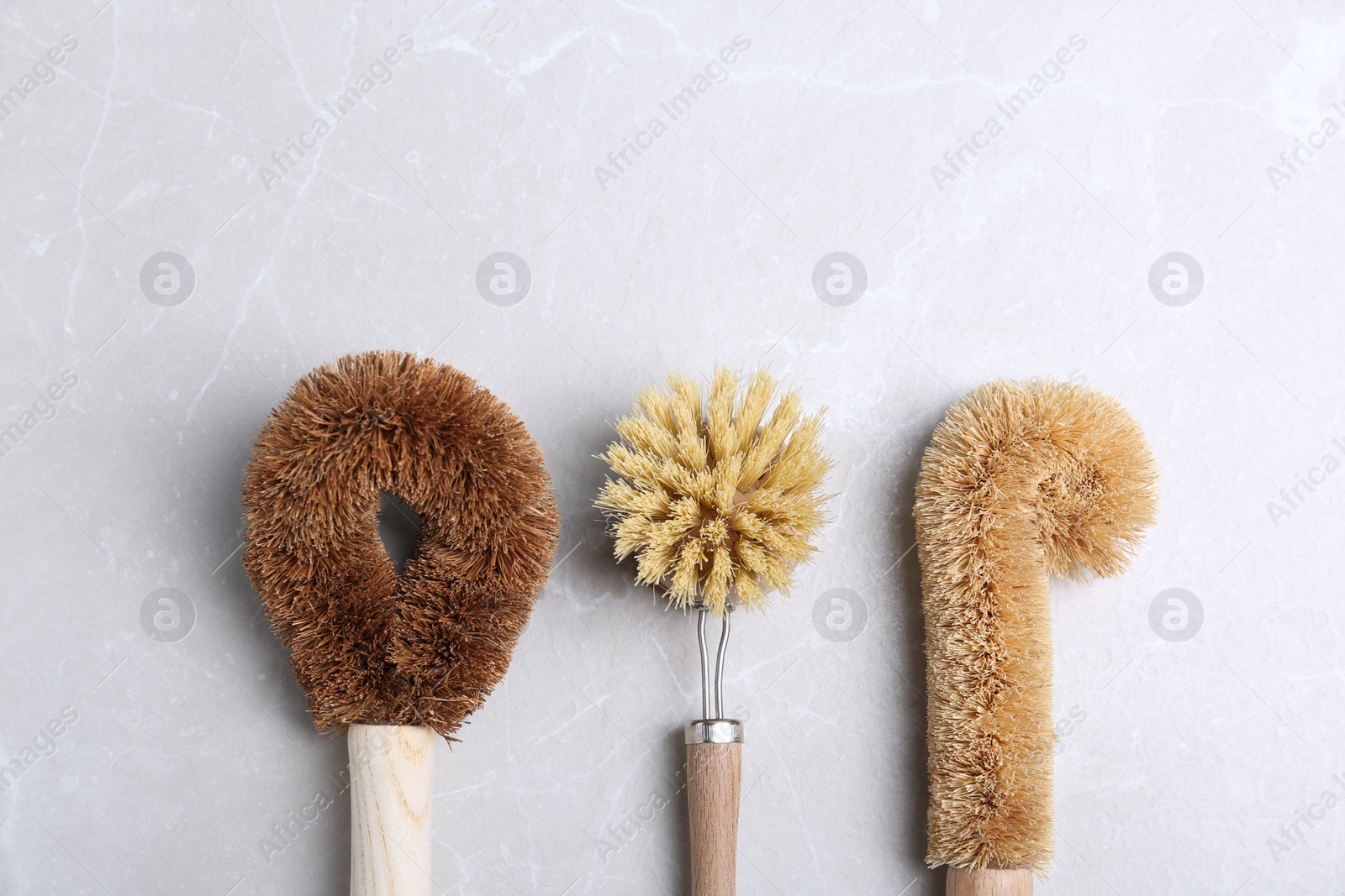 Photo of Cleaning brushes for dish washing on grey table, flat lay