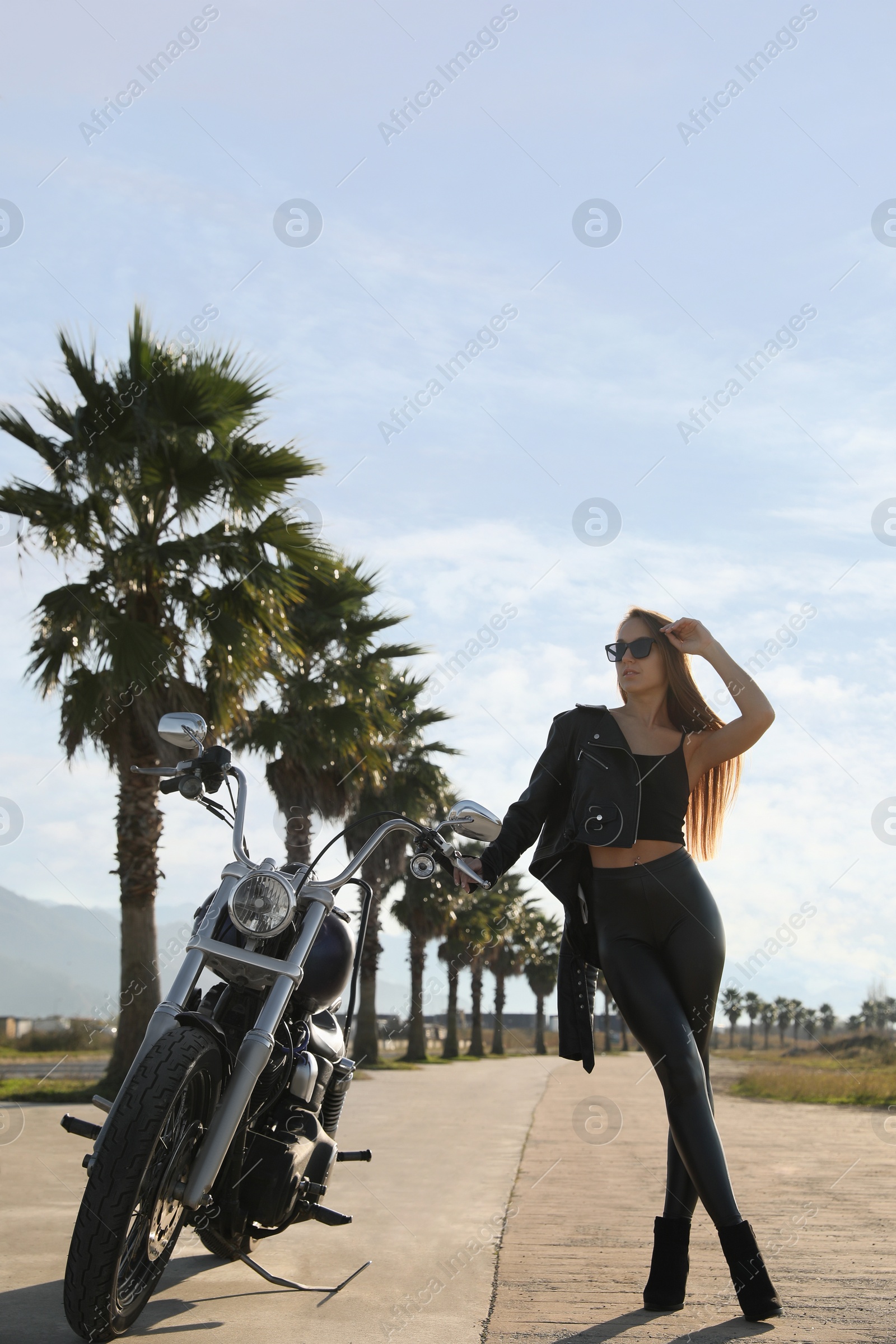 Photo of Beautiful young woman near motorcycle on sunny day