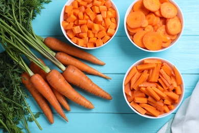 Photo of Flat lay composition with ripe carrots on light blue wooden table