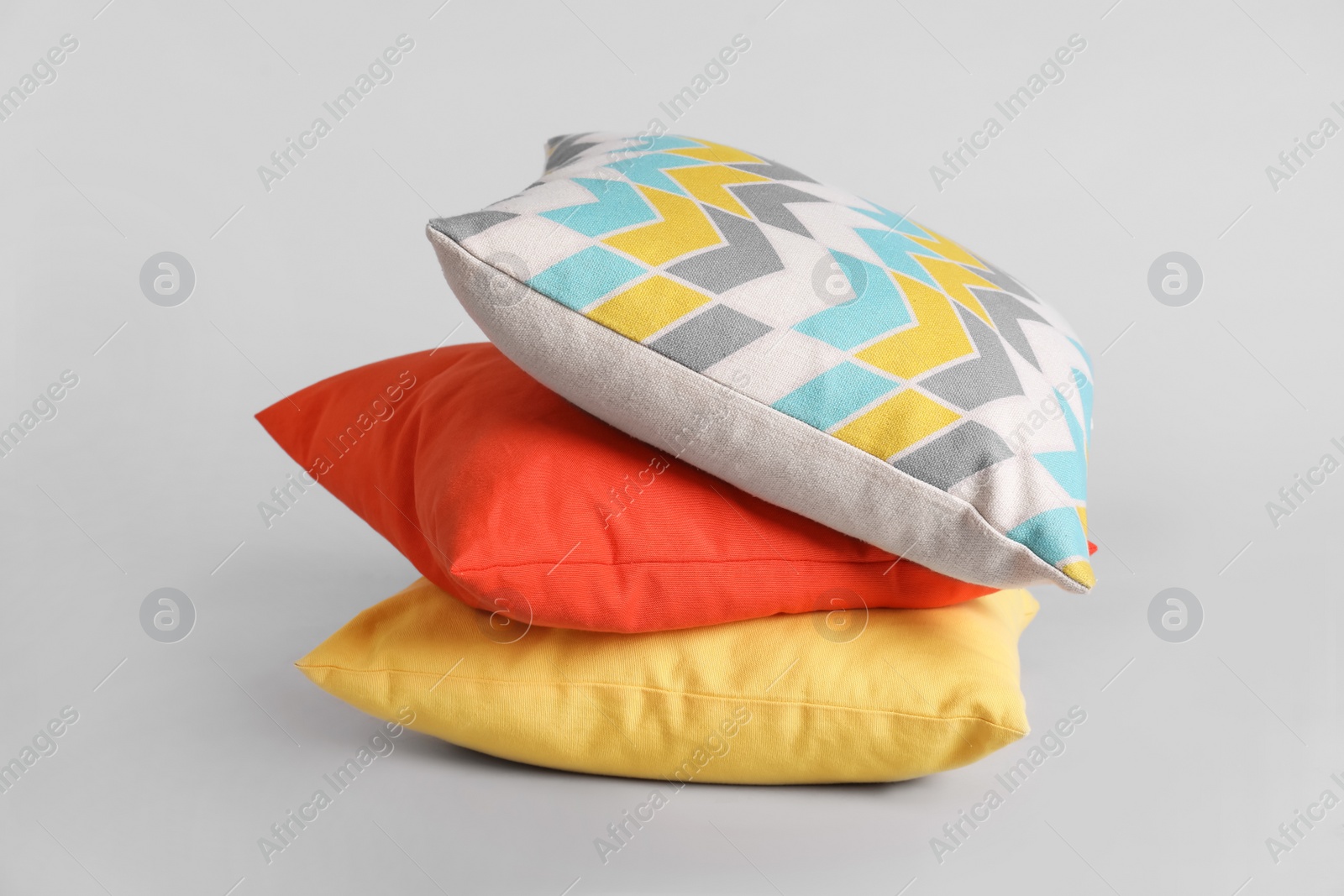 Photo of Stack of stylish soft pillows on grey background