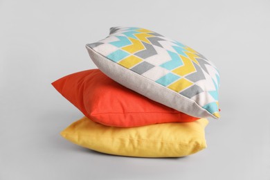 Photo of Stack of stylish soft pillows on grey background