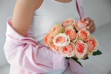 Photo of Young woman with beautiful bouquet indoors, closeup
