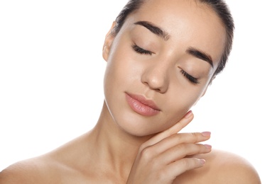 Portrait of young woman with foundation on her face against white background