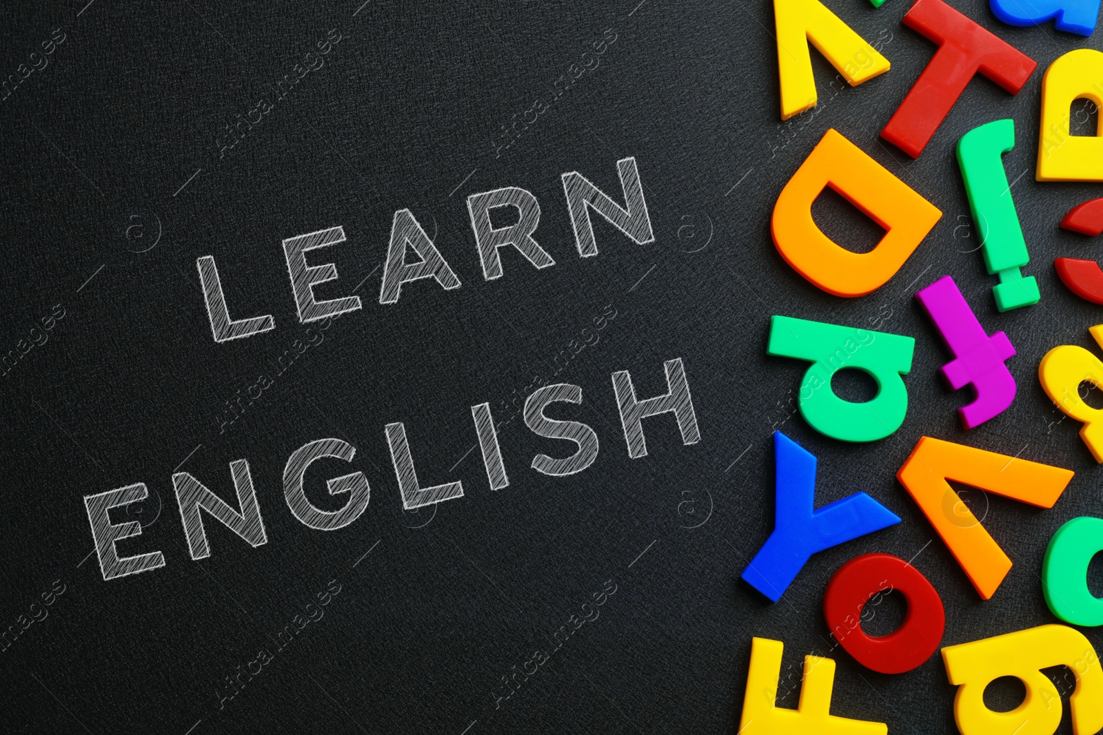 Image of Blackboard with text Learn English and plastic letters, top view