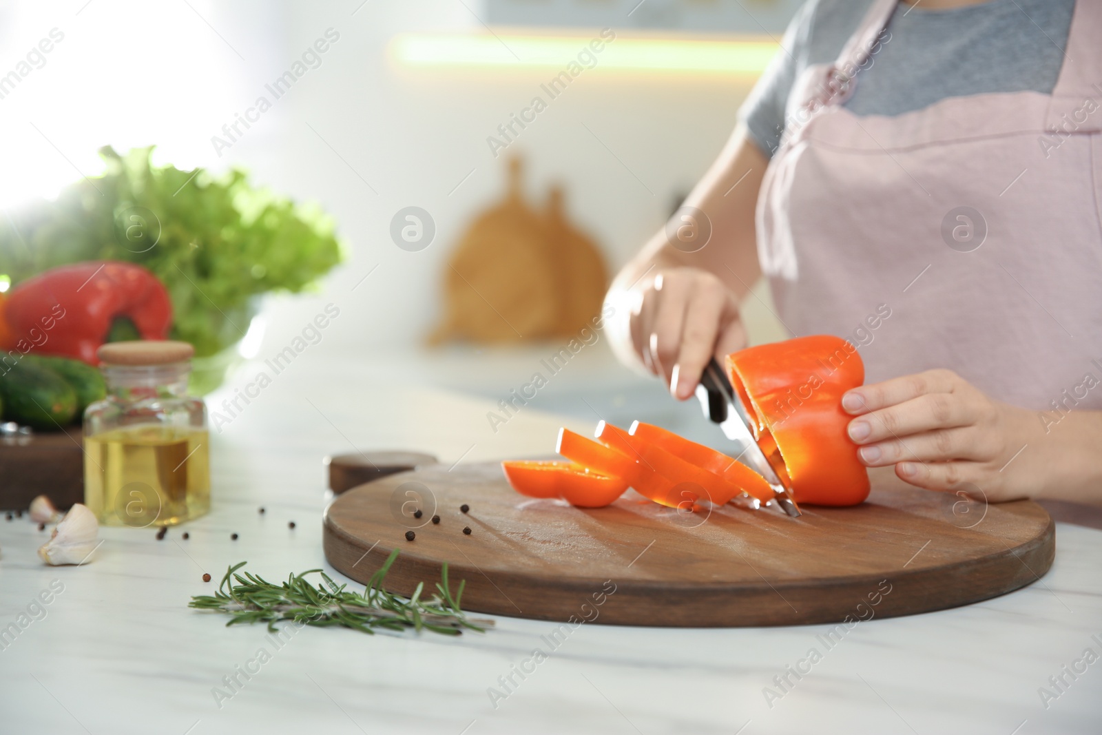 Photo of Young woman cooking at table in kitchen, closeup