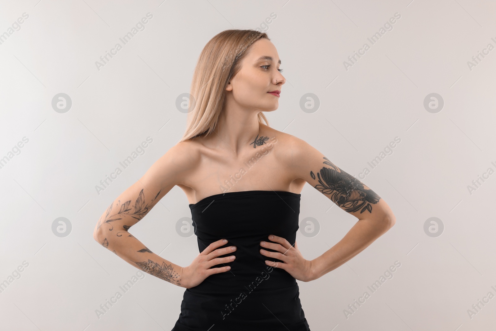 Photo of Portrait of beautiful tattooed woman on light background