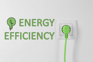 Image of Energy efficiency concept. Power socket and plug on white background
