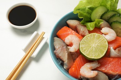 Photo of Delicious mackerel, shrimps and salmon served with lettuce, lime, cucumbers and soy sauce on white marble table, closeup. Tasty sashimi dish