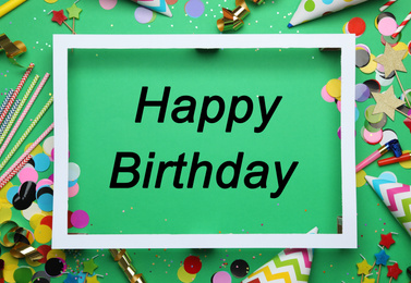 Flat lay composition with party decor and text Happy Birthday on green background