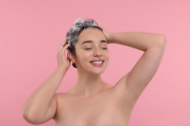 Photo of Portrait of beautiful happy woman washing hair on pink background