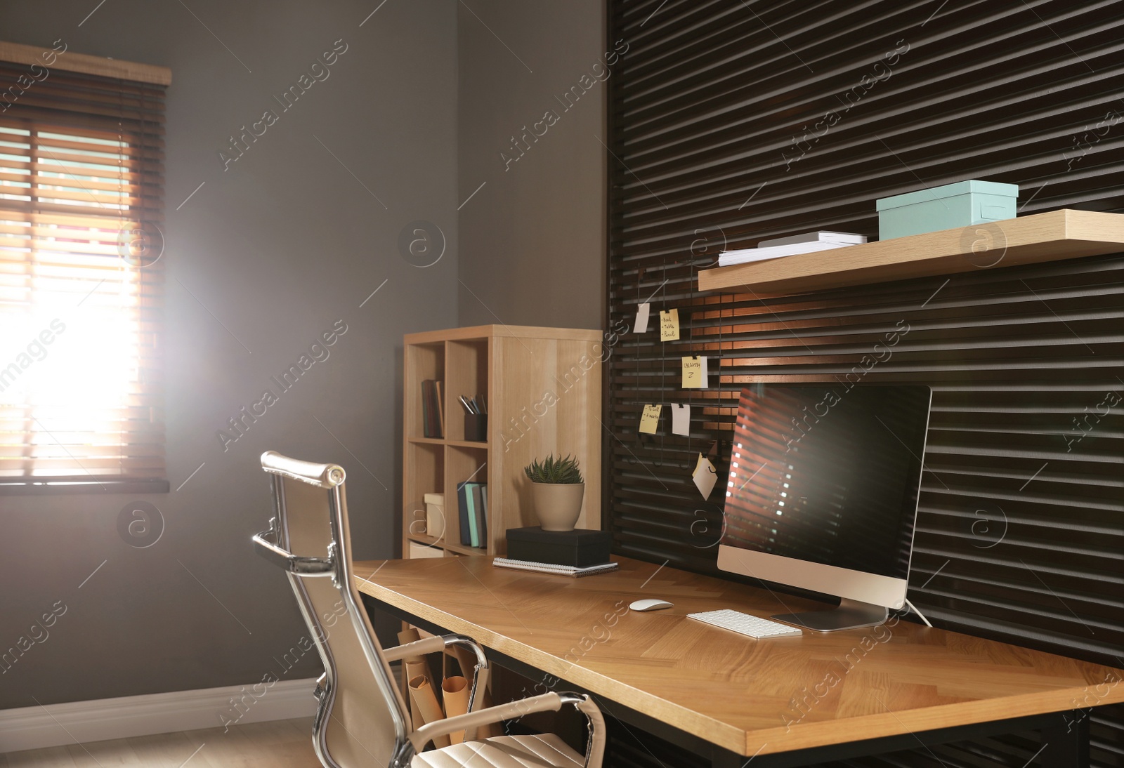 Photo of Comfortable workplace with office chair and computer on wooden table