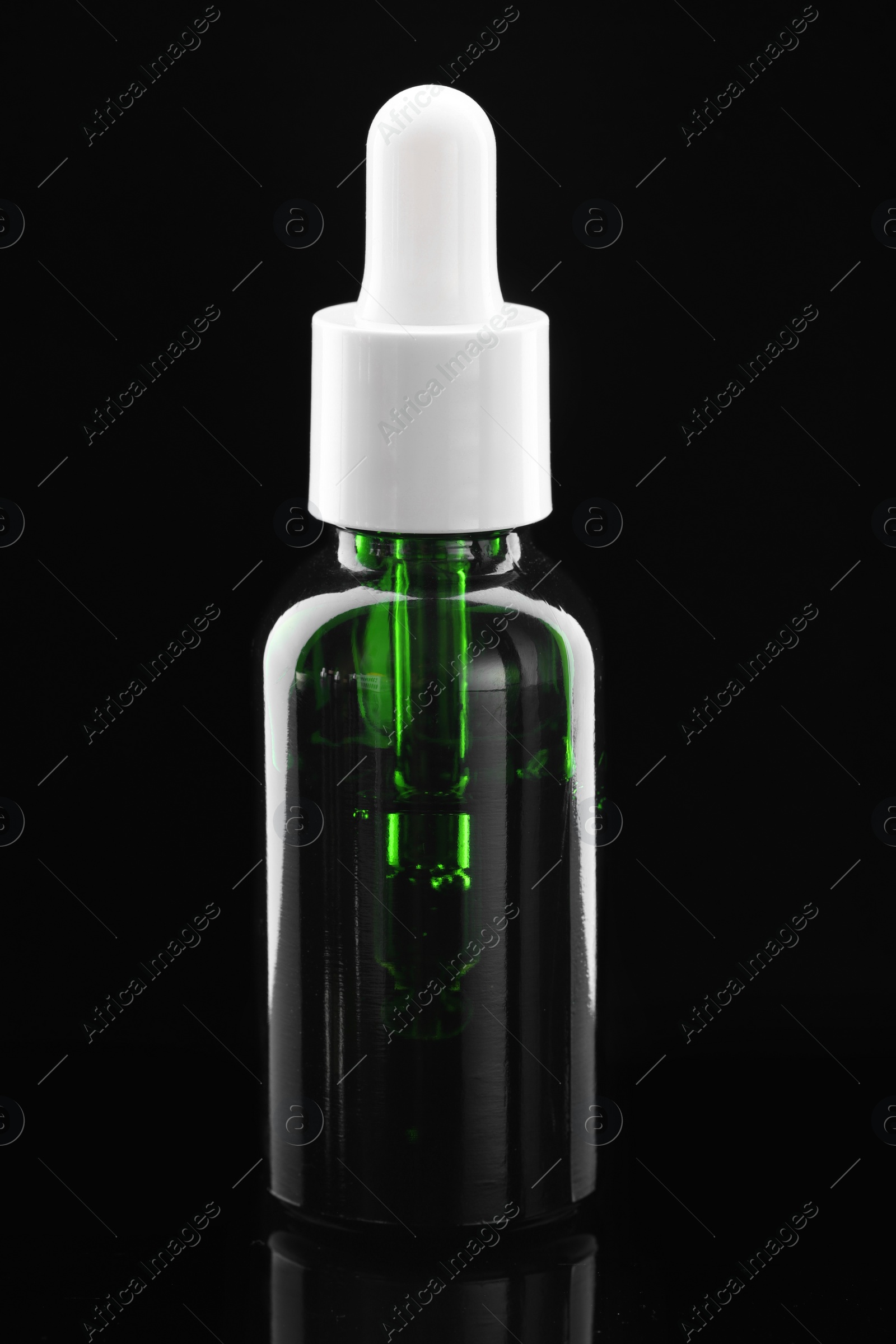 Photo of Tincture in bottle on mirror table against dark background