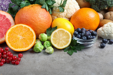 Photo of Different products rich in vitamin C on light grey table