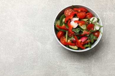 Photo of Tasty fresh vegetarian salad on light grey table, top view. Space for text