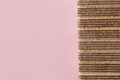 Photo of Tasty wafer sticks on pink background, flat lay with space for text. Sweet food