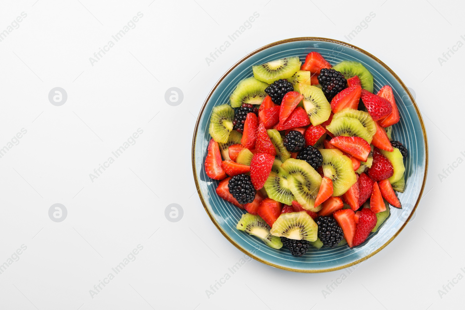 Photo of Plate of yummy fruit salad on light blue background, top view. Space for text