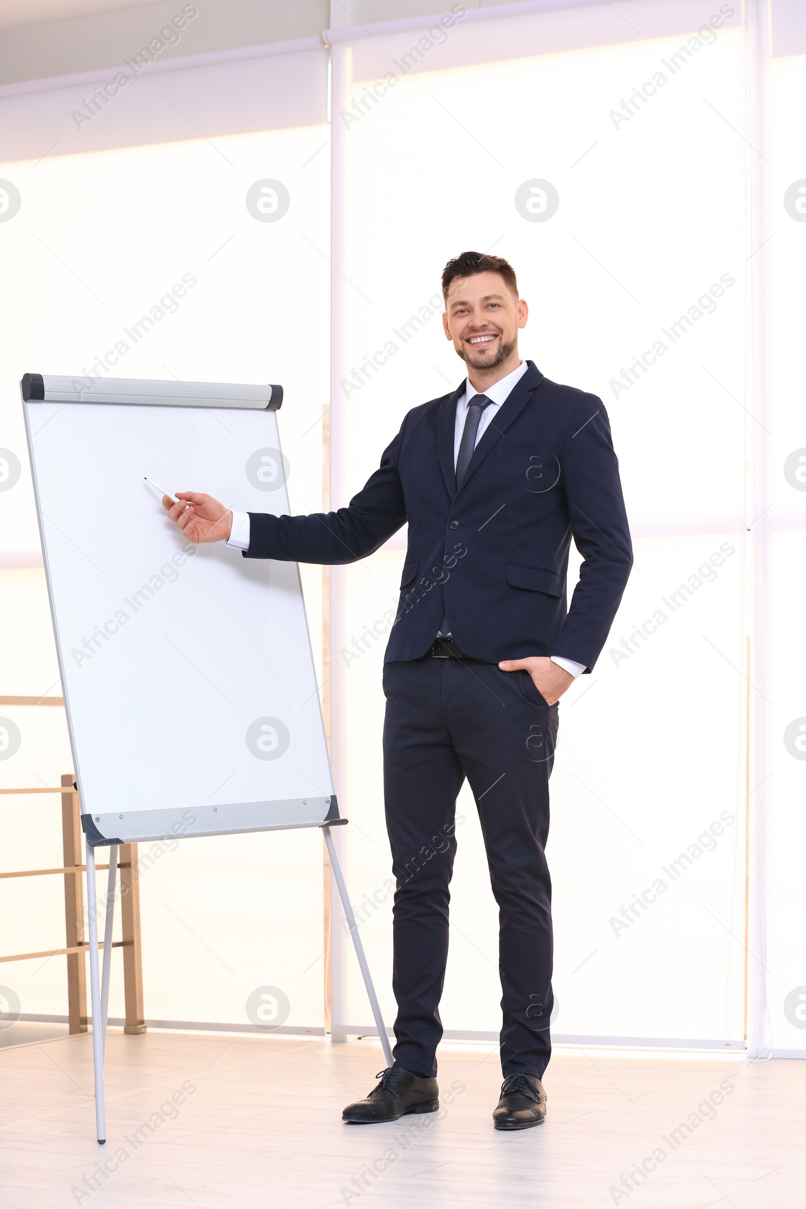 Photo of Young business trainer near flip chart, indoors