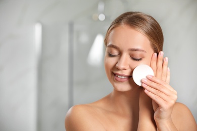 Photo of Beautiful young woman with cotton pad indoors