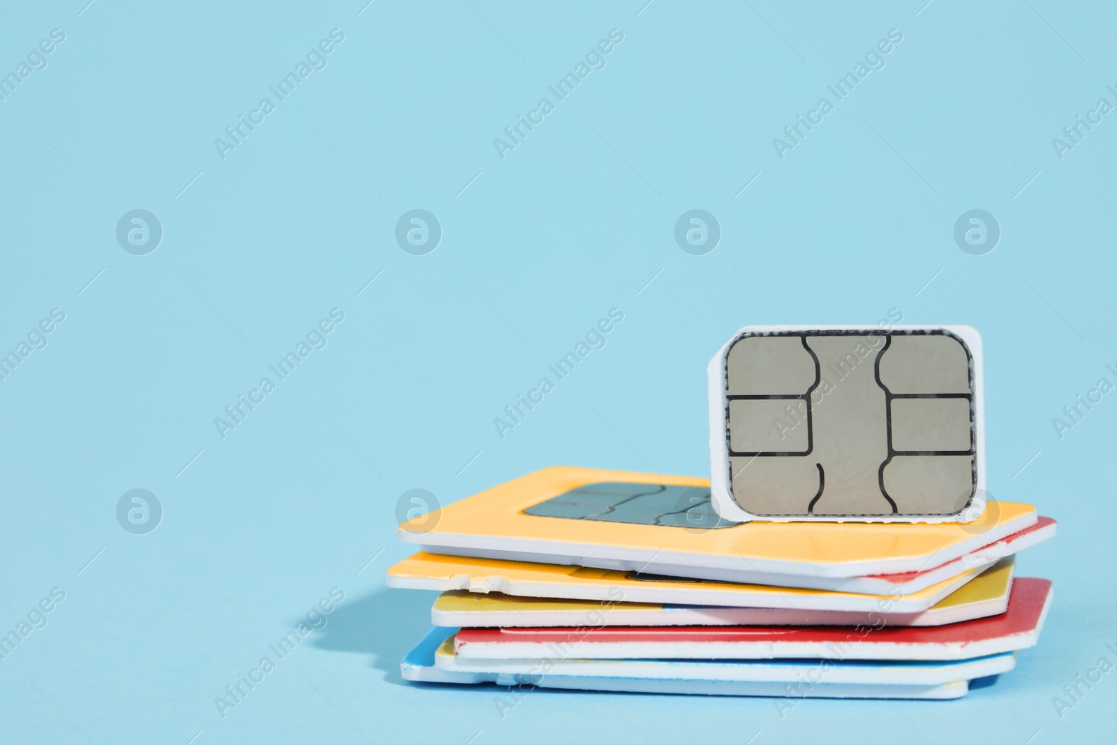 Photo of Different SIM cards on light blue background. Space for text