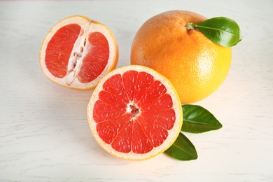 Photo of Whole and sliced tasty grapefruits on white background