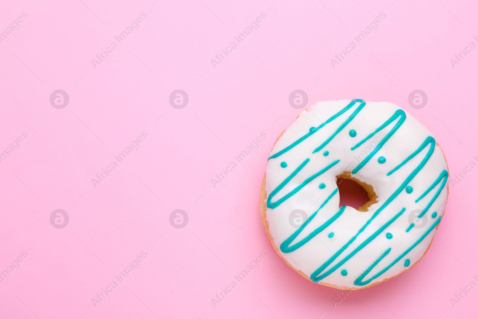 Photo of Tasty glazed donut on pink background, top view. Space for text