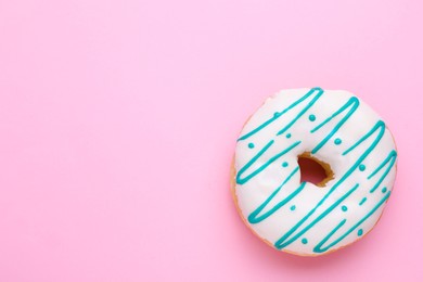 Tasty glazed donut on pink background, top view. Space for text
