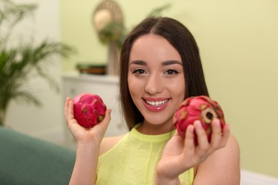 Young woman with fresh pitahayas at home. Exotic fruits