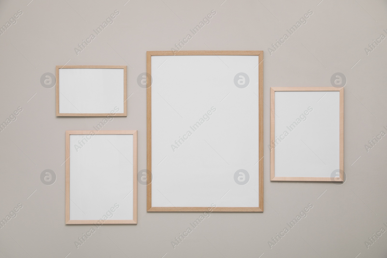 Photo of Empty frames on grey wall. Mockup for design