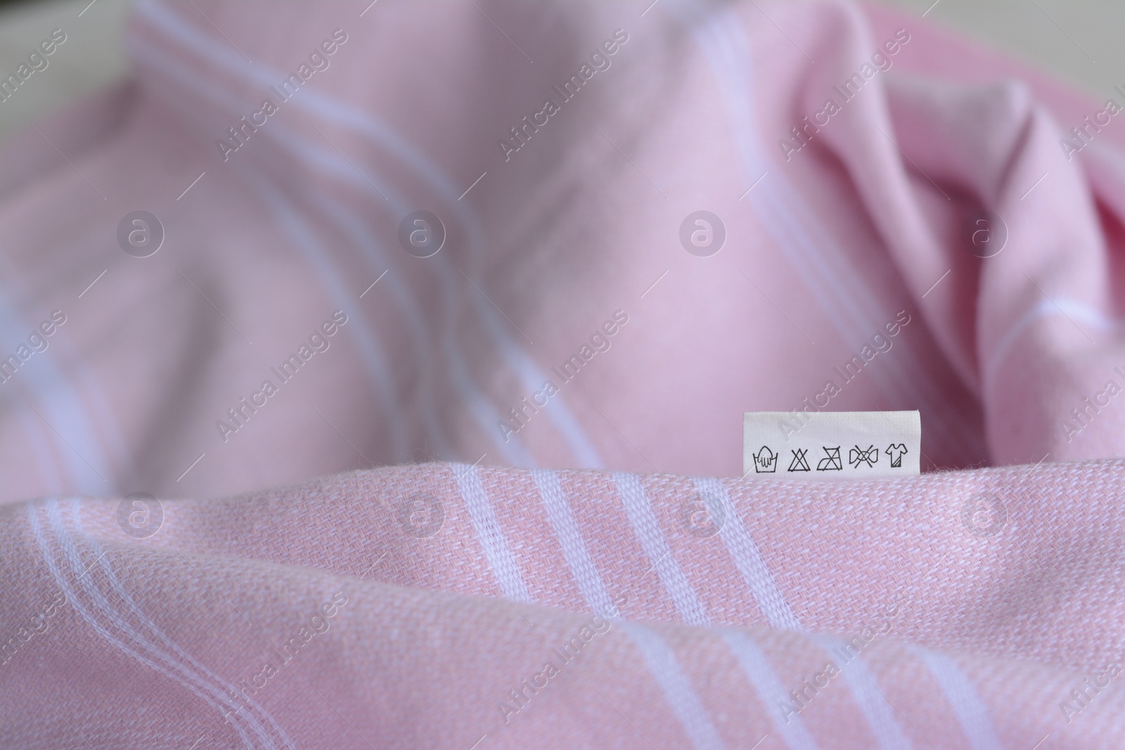 Photo of White clothing label on pale pink garment