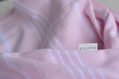 White clothing label on pale pink garment