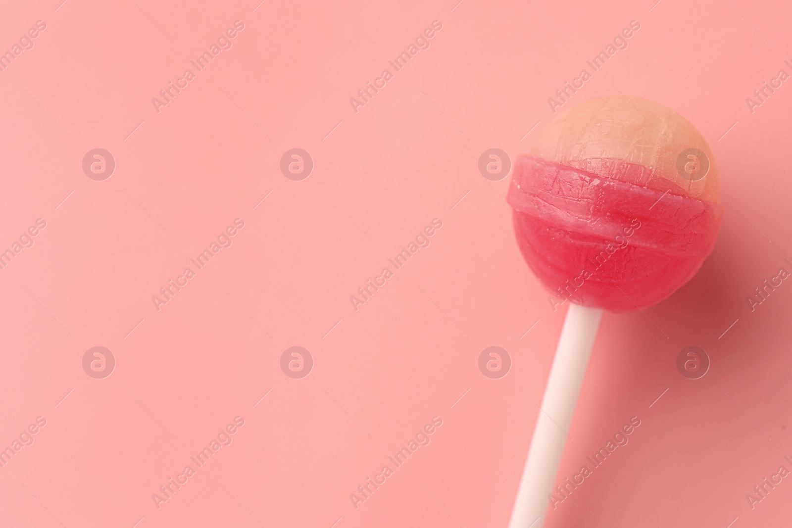 Photo of Tasty lollipop on pink background, top view. Space for text