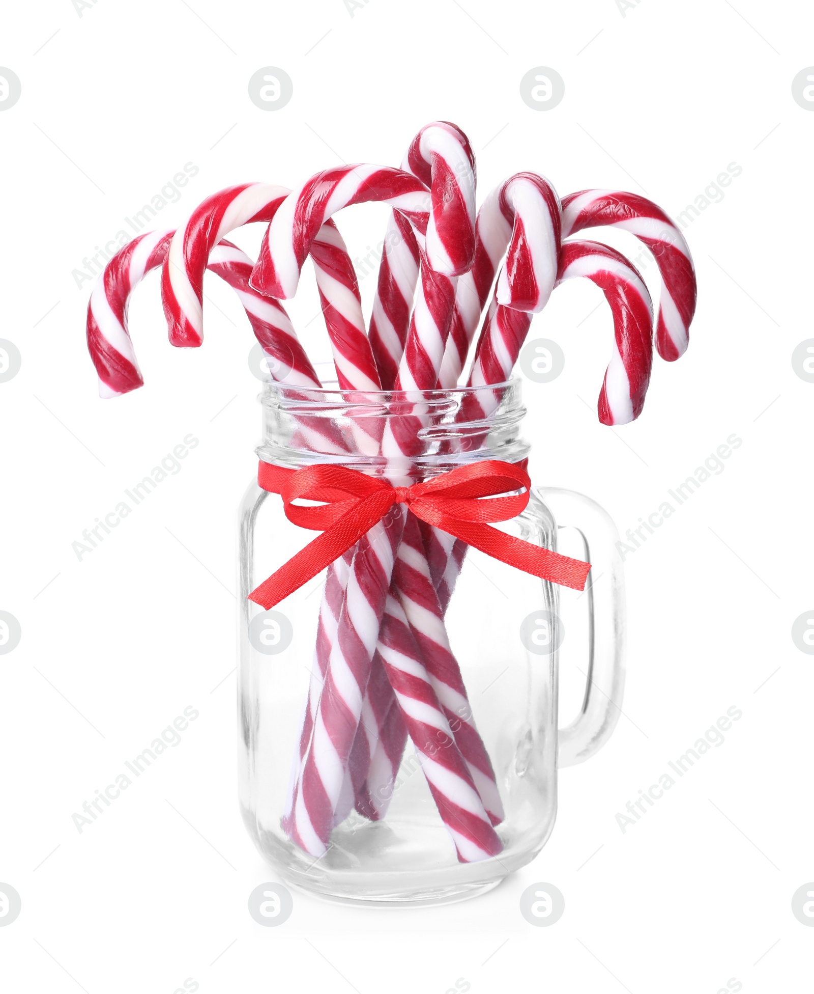 Photo of Sweet Christmas candy canes in glass mason jar on white background