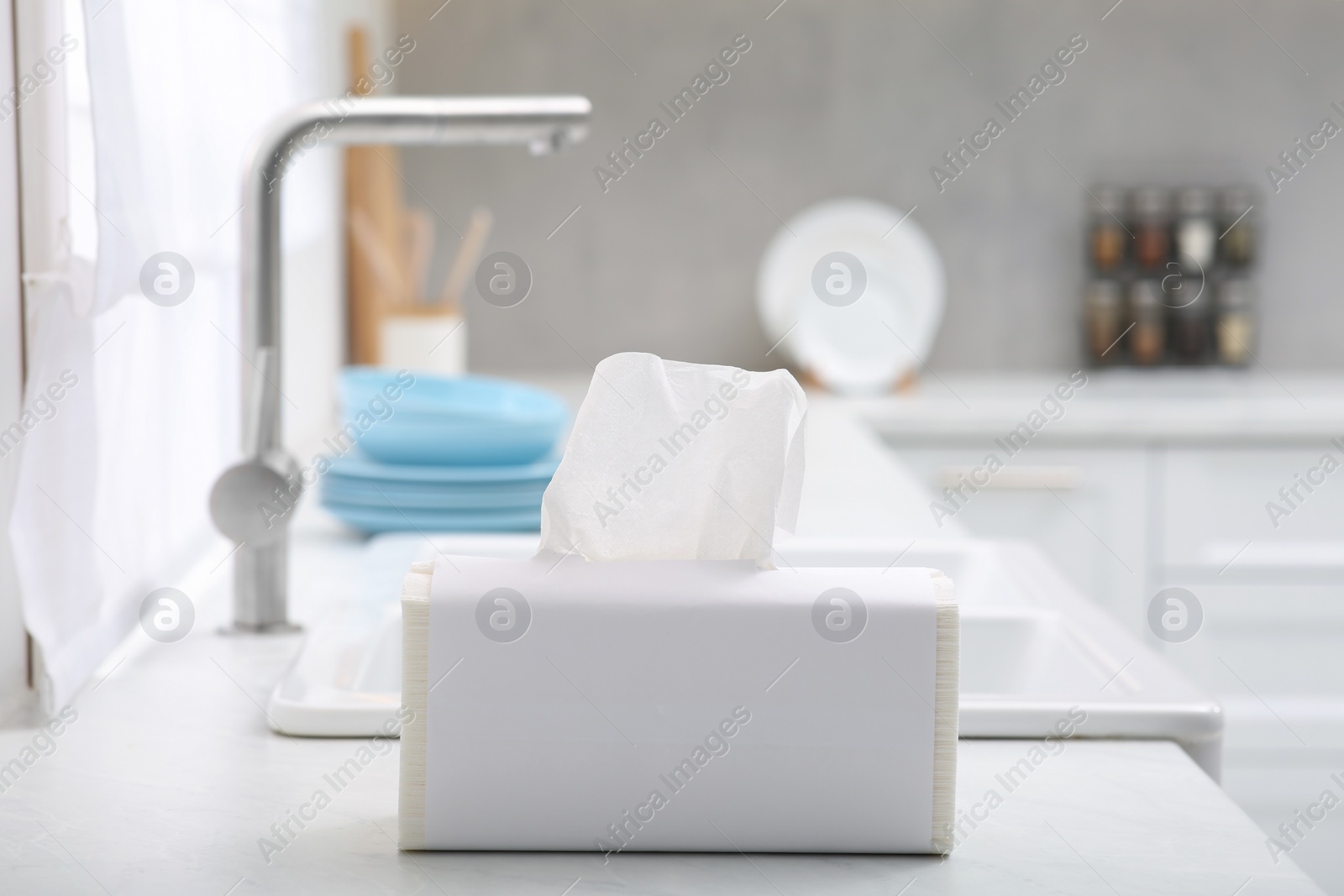 Photo of Package of paper towels on white countertop near sink in kitchen