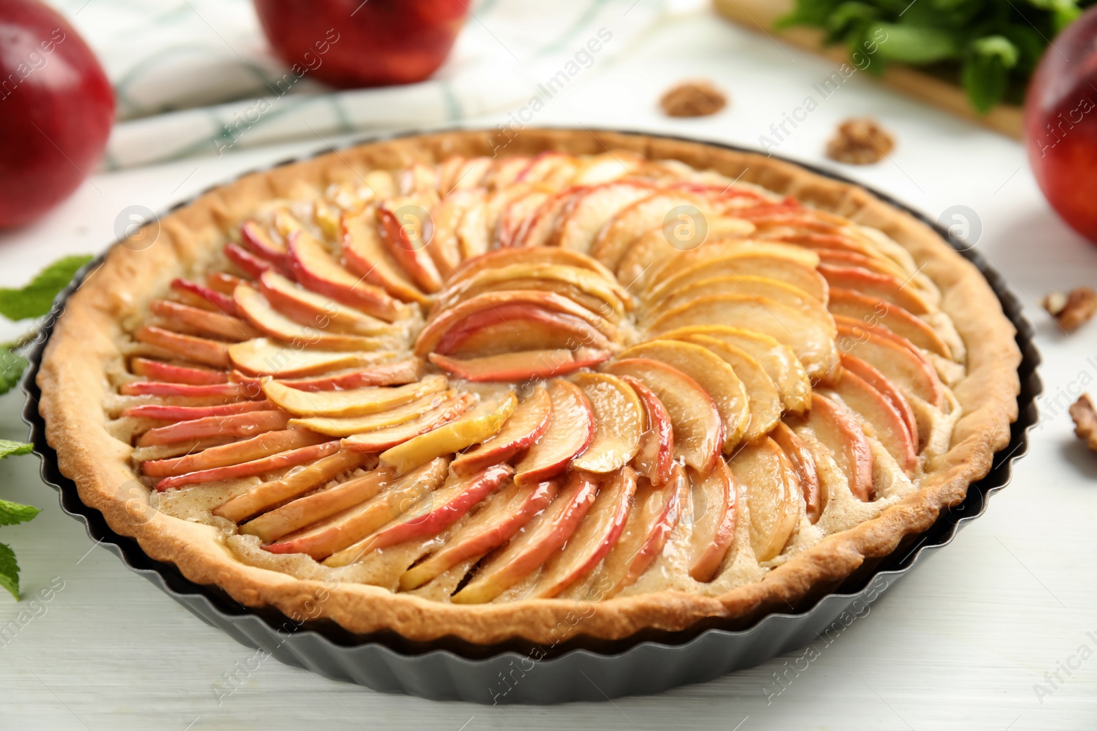 Photo of Delicious homemade apple tart on white wooden table